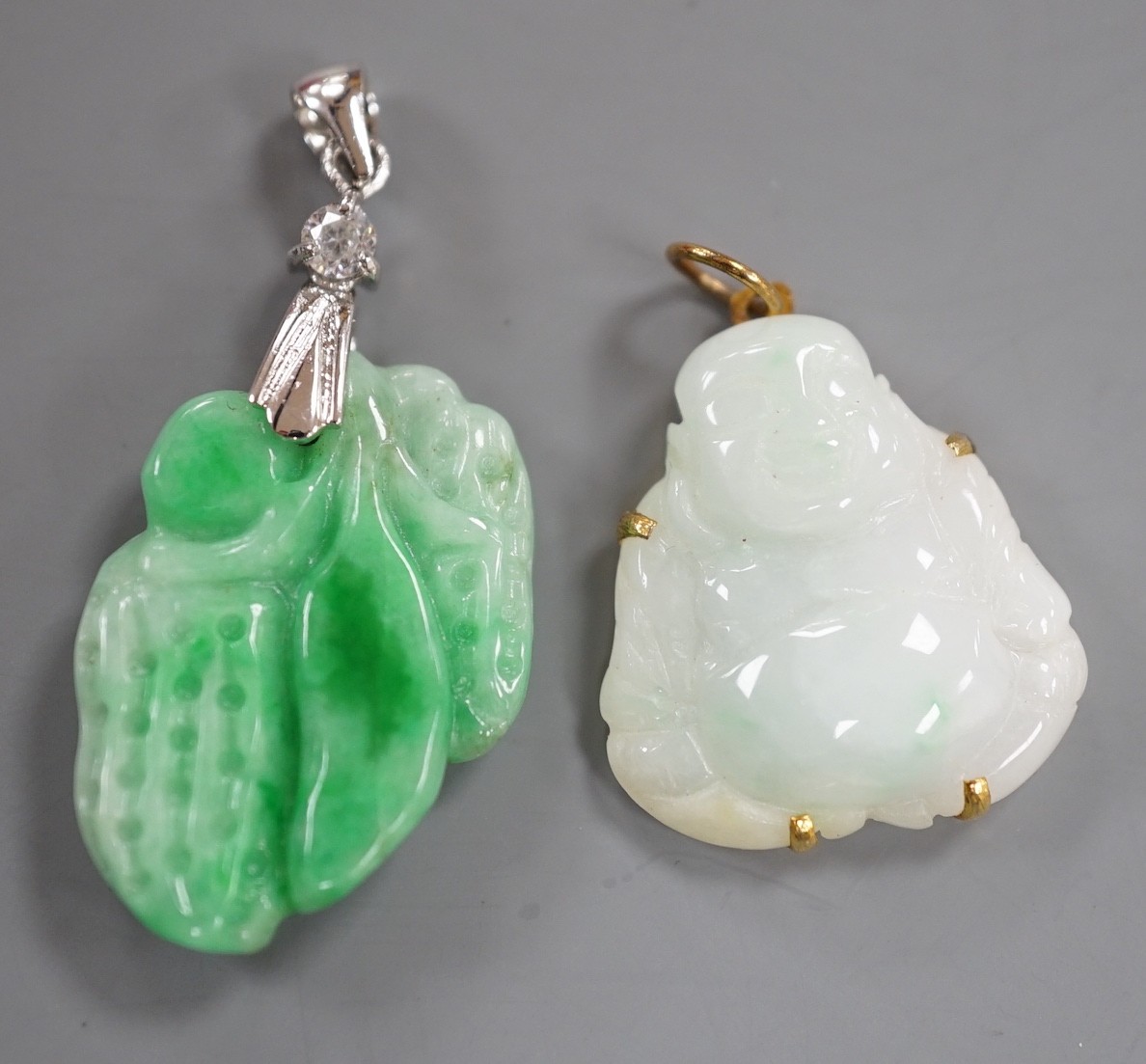 A modern 18k gold plated and simulated diamond mounted carved jade pendant, overall 39mm and a gilt metal mounted carved jade pendant.